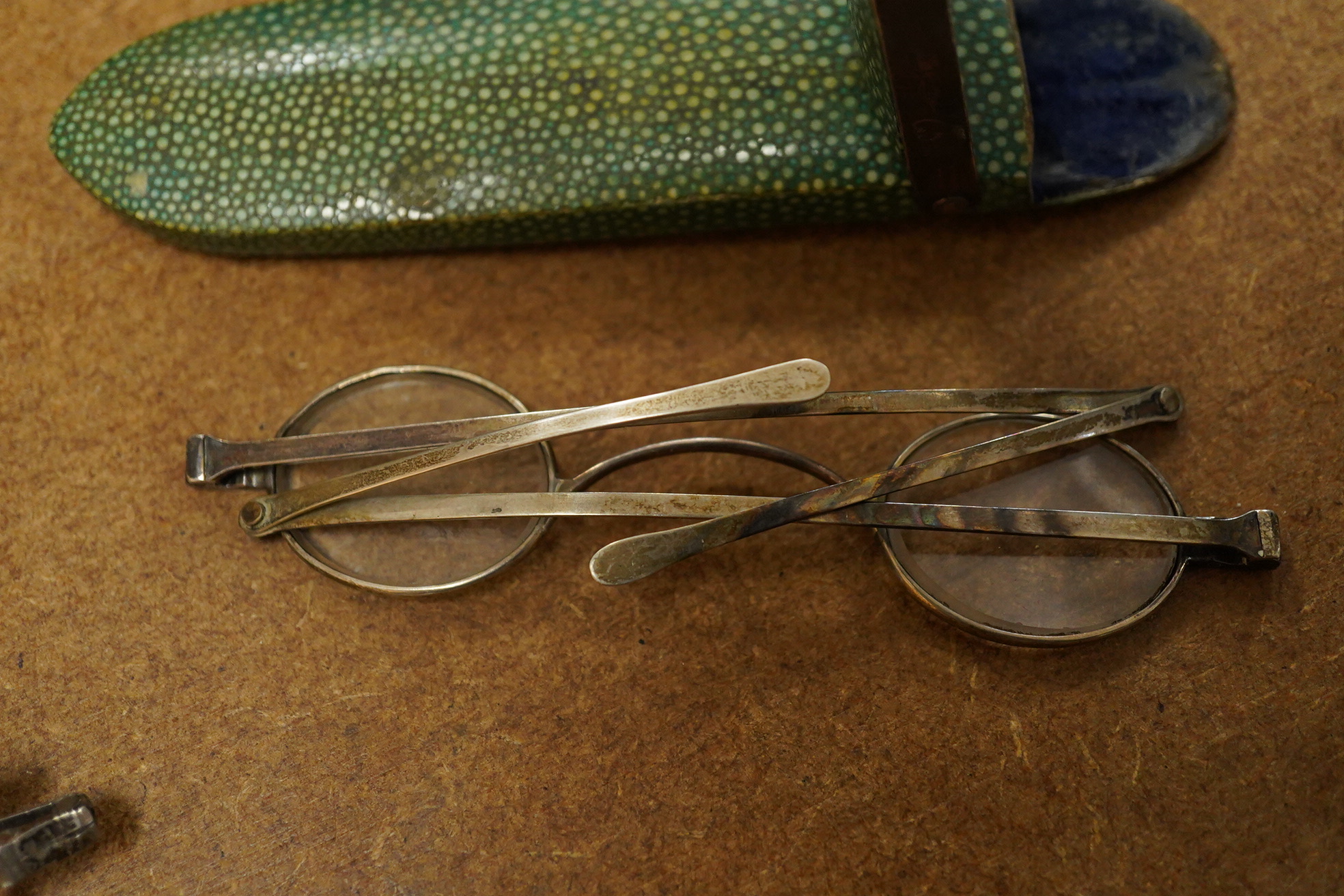 A pair of George III silver framed turn pin spectacles, mm. IH, London 1816, shagreen case, a pair of William IV silver slider spectacles by Thomas Millington, Birmingham, card case (2)